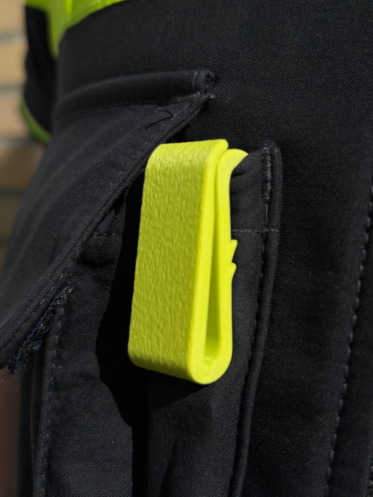 Gele dienstclip in de penhouder van een steekvest