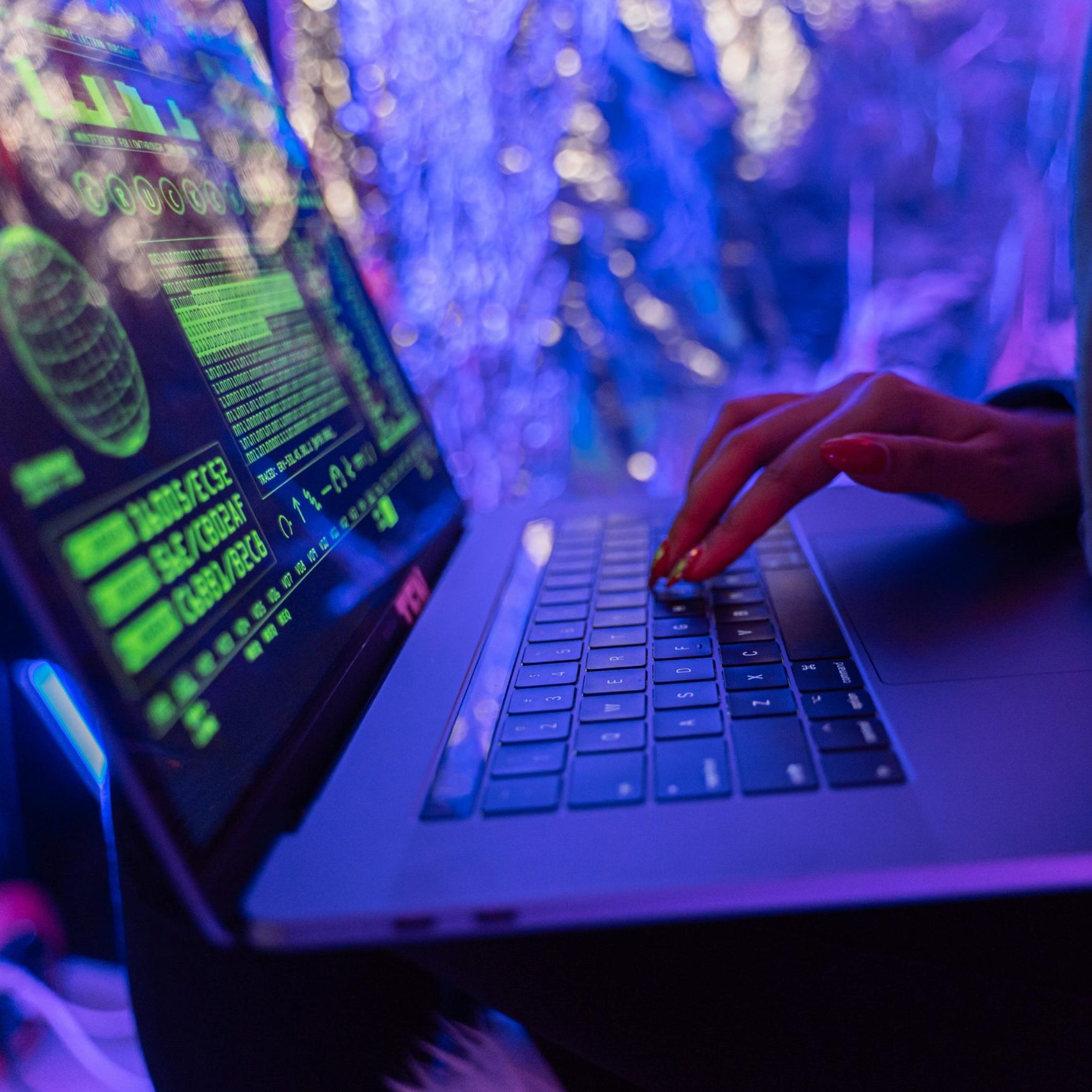 Mani che digitano su un portatile con codice di sicurezza sullo schermo