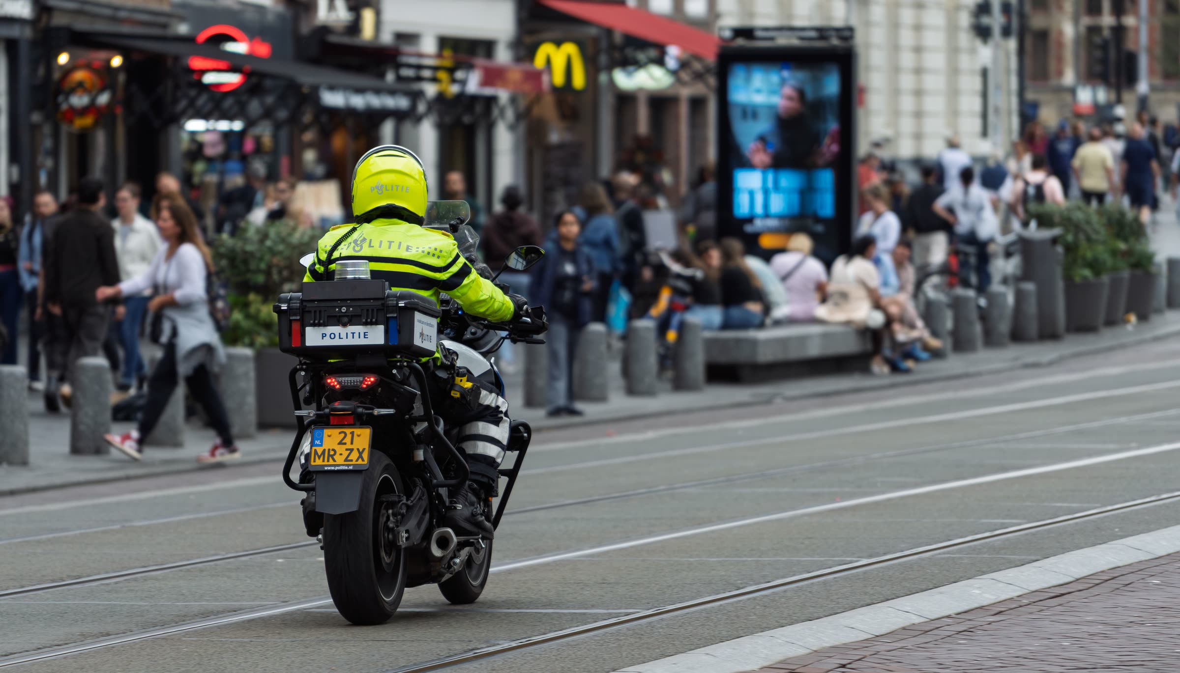 Polizist auf einem Motorrad in einer belebten Einkaufsstraße